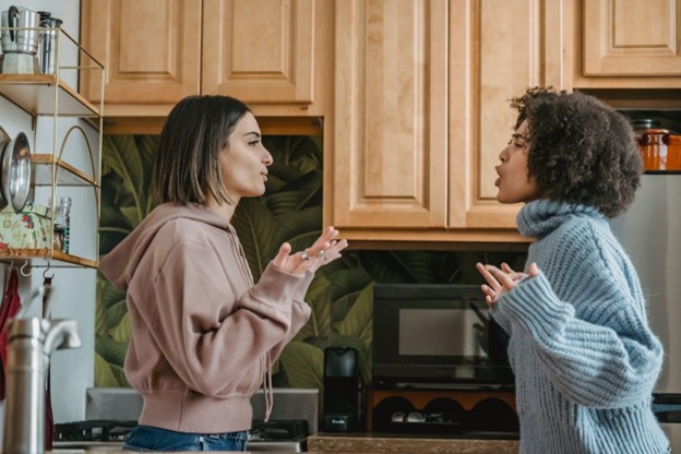 Two females having a conflict in a kitchen