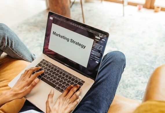 a-person-typing-on-a-laptop-with-marketing-strategy-written-across-the-screen