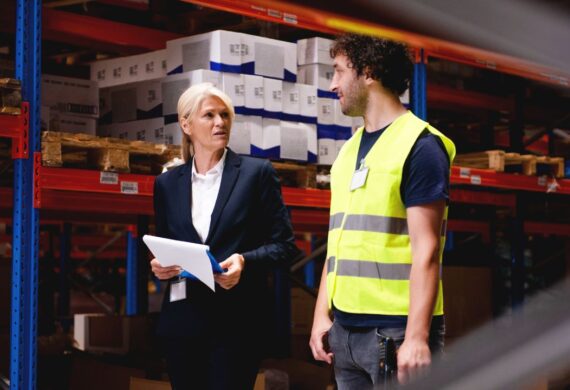 Property manager speaking with warehouse employee inside a small industrial or flex commercial space