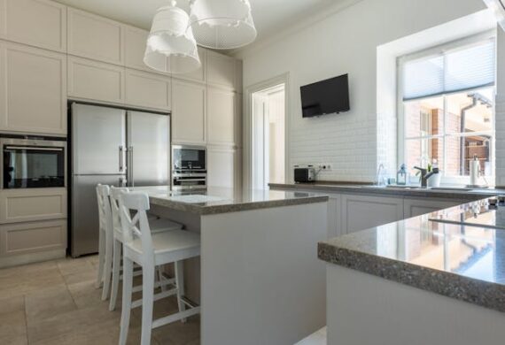 a white modern kitchen with granite counters