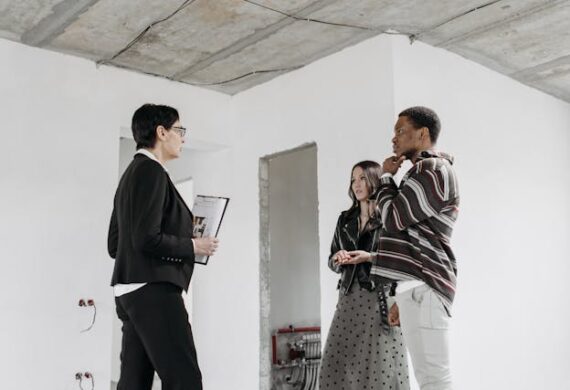 woman-with-clipboard-talking-to-two-people-in-renovated-space